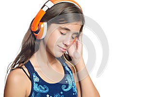 Beautiful hispanic teenage girl enjoying music on bright orange headphones