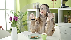 Beautiful hispanic woman having breakfast meditating at dinning room