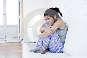 Beautiful hispanic woman in painful expression holding belly suffering menstrual period pain