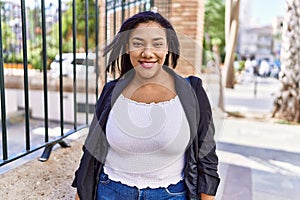 Beautiful hispanic woman smiling at the camera, walking outdoors on a sunny day