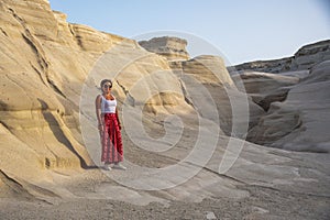 Beautiful Hispanic woman surrounded by white rocks. Sarakiniko, Milos Island, Greece.