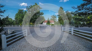 Beautiful historic noble manor house - paved driveway and low wooden fence.