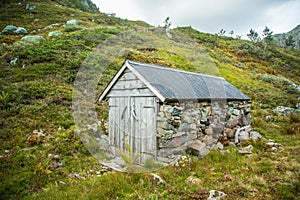 A beautiful, historic stone buildings in the mountains of Folgefonna National Park in Norway. Old houses with grass roofs near the
