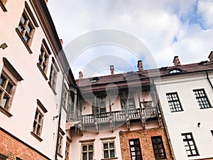 Beautiful historical medieval European low-rise buildings with a red tile roof gable and rectangular windows with bars