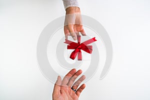 Beautiful holiday or Christmas background image of a mixed race African American woman handing a small red ribbon wrapped gift box