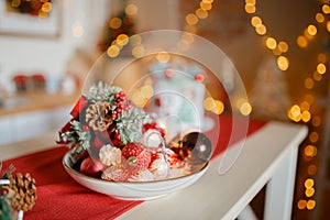 Beautiful holiday decorated kitchen with Christmas tree and bright lights , holiday glasses on the main plan, blur background