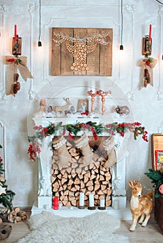 Beautiful holiday decorated room with Christmas tree, fireplace and with presents. Cozy winter scene. White interior.