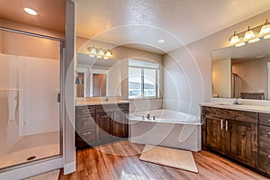 Beautiful home bathroom with built in corner bathtub between two vanity units