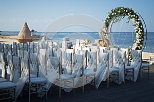 Beautiful horizontal shot of an arch decorated with flowers and white chairs for a wedding ceremony