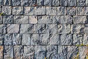 A beautiful horizontal texture of part of an old gray brick wall from frozen volcanic lava from Etna volcano in Sicily in Italy on