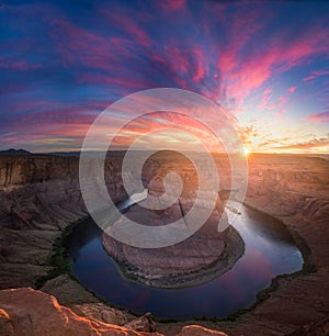Beautiful Horseshoe Bend sunburst sunset and colorful clouds with reflections