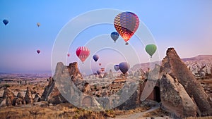 Beautiful hot air balloons flying over Cappadocia landscape at sunrise