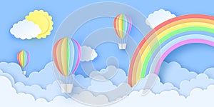 Beautiful hot air balloons flying over fluffy clouds in the sky with sun and rainbow