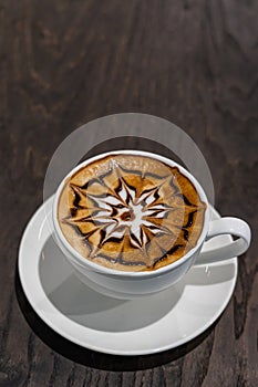 Beautiful hot art mocha coffee on dark wooden table