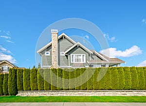 Beautiful house behind a green hedge fence