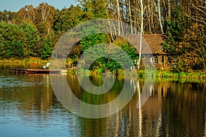 Beautiful house reflected in the lake. Autumn landscape.