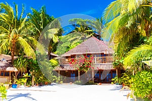 Beautiful house to a reed roof standing on a white, sandy beach