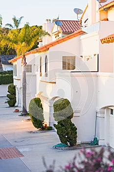 Beautiful houses with nicely landscaped front the yard, and green hills in the background in a small beach town in California at
