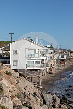 beautiful houses at wooden support poles at the scenic beach in Malibu, California, USA