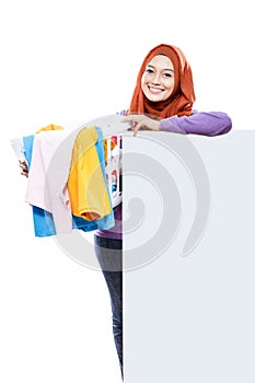 Beautiful housewife carrying laundry basket full of dirty clothe