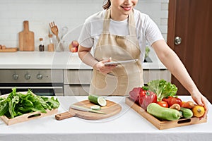 Beautiful housewife lady hold digital tablet searching recipe internet lecture master class cook delicious family dinner