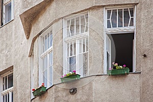 Beautiful Hungarian architecture in Budapest, Europe. Blooming flowers on the window sill in front of white framed windows, old
