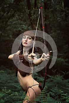 Beautiful huntress aiming with bow