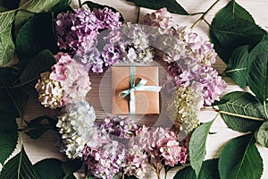 Beautiful hydrangea flowers and gift box on rustic white wood, flat lay. Happy mothers day greeting card mockup. International