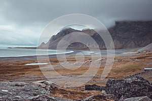 Beautiful icelandic landscape in early morning. Yellow grass, sunrise, clouds and bay in the distance. Very beautiful scenery