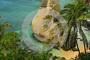 Beautiful and idyllic scenic view of sea landscape at tropical island paradise beach with diamond shape rock cliff palm trees and
