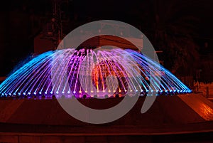 Beautiful illuminated colorful city fountain at night time