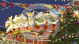 Beautiful illuminated merry-go-round details while rounding at Christmas fair in slow motion. Vintage colorful carousel