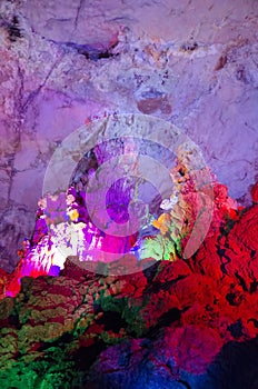beautiful illuminated multicolored stalactites from karst Reed Flute cave. Guilin Guangxi China