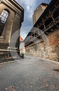 Beautiful image of narrow pathway in the ancient castle between stone wall and building