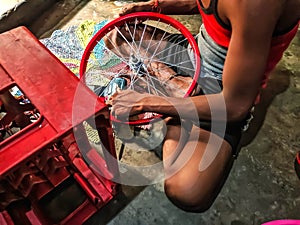 Beautiful image of a worker fitting bycycle rim india