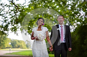 Beautiful indian bride and caucasian groom in park