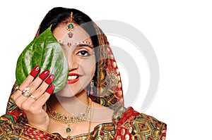 Beautiful Indian bride in red sari holding a leaf. photo