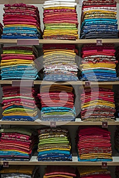 Beautiful Indian coloured cloth fabric folded on shelves for sale, India