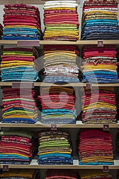 Beautiful Indian coloured cloth fabric folded on shelves for sale, India