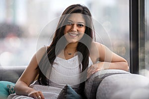 Beautiful Indian ethnicity woman with perfect white teeth smile after dental visit, smiling cheerful relaxed at home