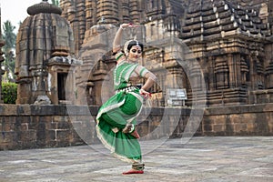 Beautiful indian girl dancer of Indian classical dance Odissi posing in front of Mukteshvara Temple, Bhubaneswar, Odisha, India.Od