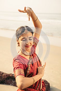 Beautiful indian woman dancer in traditional clothes at sunset