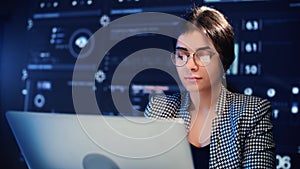 Beautiful Indian woman with eyeglasses working with computer in office of modern digital company