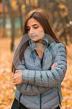 Beautiful indian woman generation z relaxing and feeling nature at autumn park in fall season copy space. Diversity and