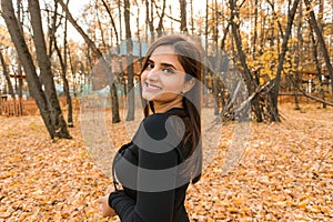 Beautiful indian woman generation z relaxing and feeling nature at autumn park in fall season. Diversity and gen z youth