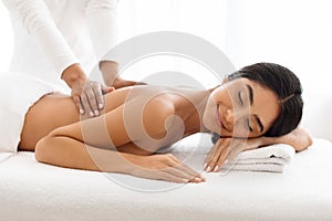 Beautiful indian woman receiving relaxing back massage