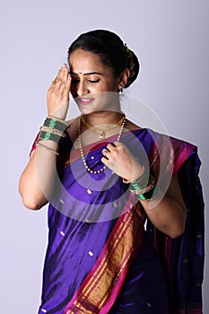 Beautiful Indian women wearing saree showing hand gestures while smiling.