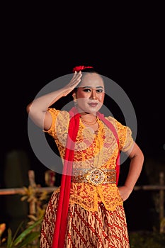 Beautiful Indonesian women wearing an orange traditional dance costume called kebaya when dancing a danced called jaipong