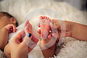 Beautiful infant baby feet in mother palm. feet of little baby, newborn baby foot, newborn baby finger