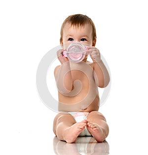 Beautiful infant baby girl toddler sitting in diaper with bottle of water